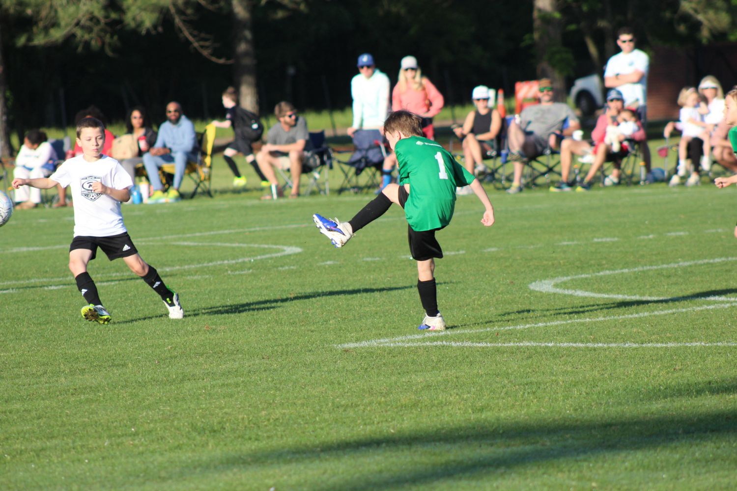 A young Jackson Futbol Club player kicking a soccer ball during a match